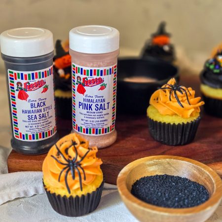 Halloween cupcake finished with orange frosting and plastic spider on top