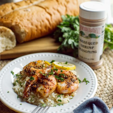 Freshly prepared Barbecued Shrimp on a bed of white rice with French bread created with River Road Brand New Orleans-style Barbecued Shrimp Seasoning.